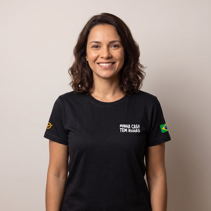 Mulher vestindo a Camiseta Não Pago IPTU preta, de frente, com "Minha casa tem rodas" no peito